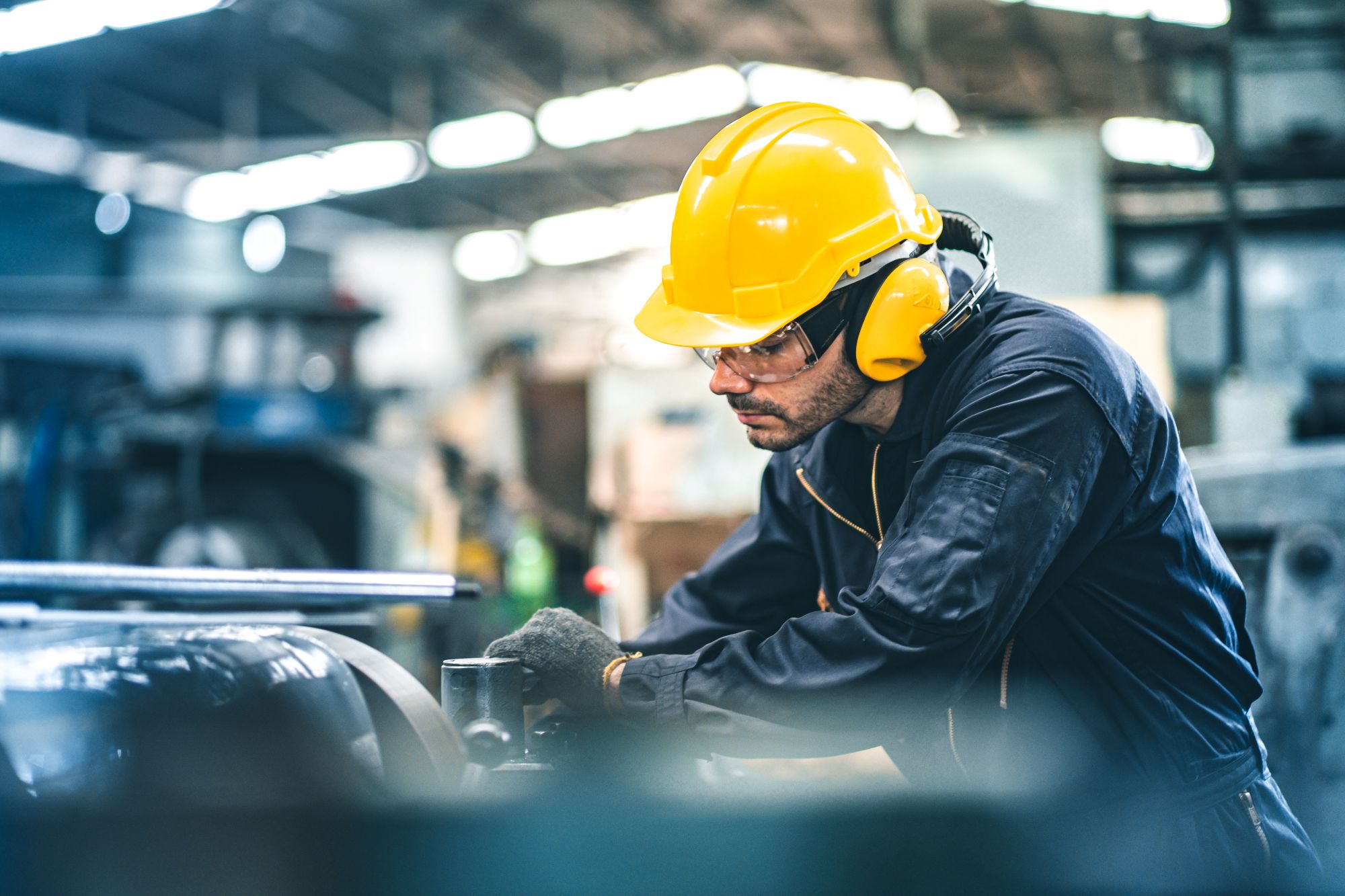 worker wearing safety gear and operating machinery